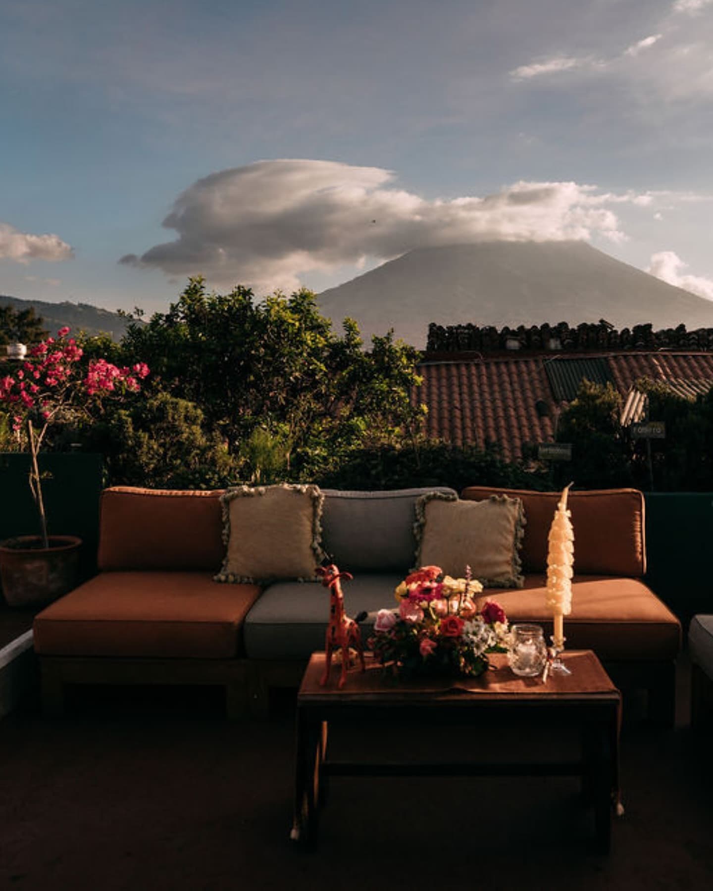 Terraza de Casa Troccoli con sillones, flores y el volcán de Agua al fondo.